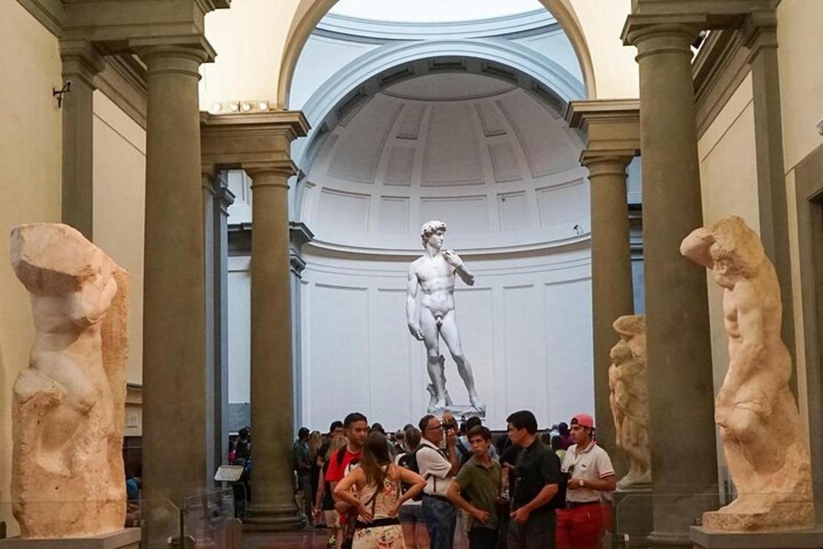 grupa ludzi stojąca przed statuą w muzeum