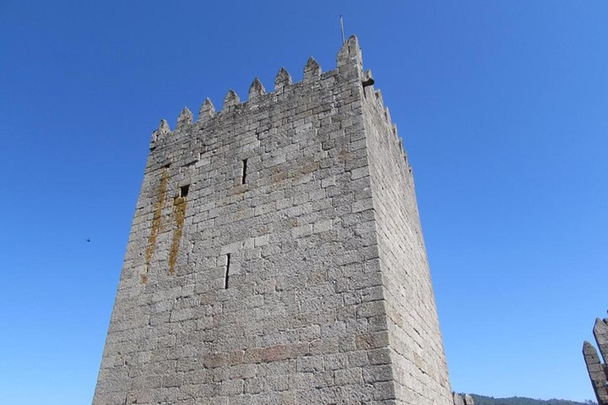 uma torre alta de tijolos com um relógio nela