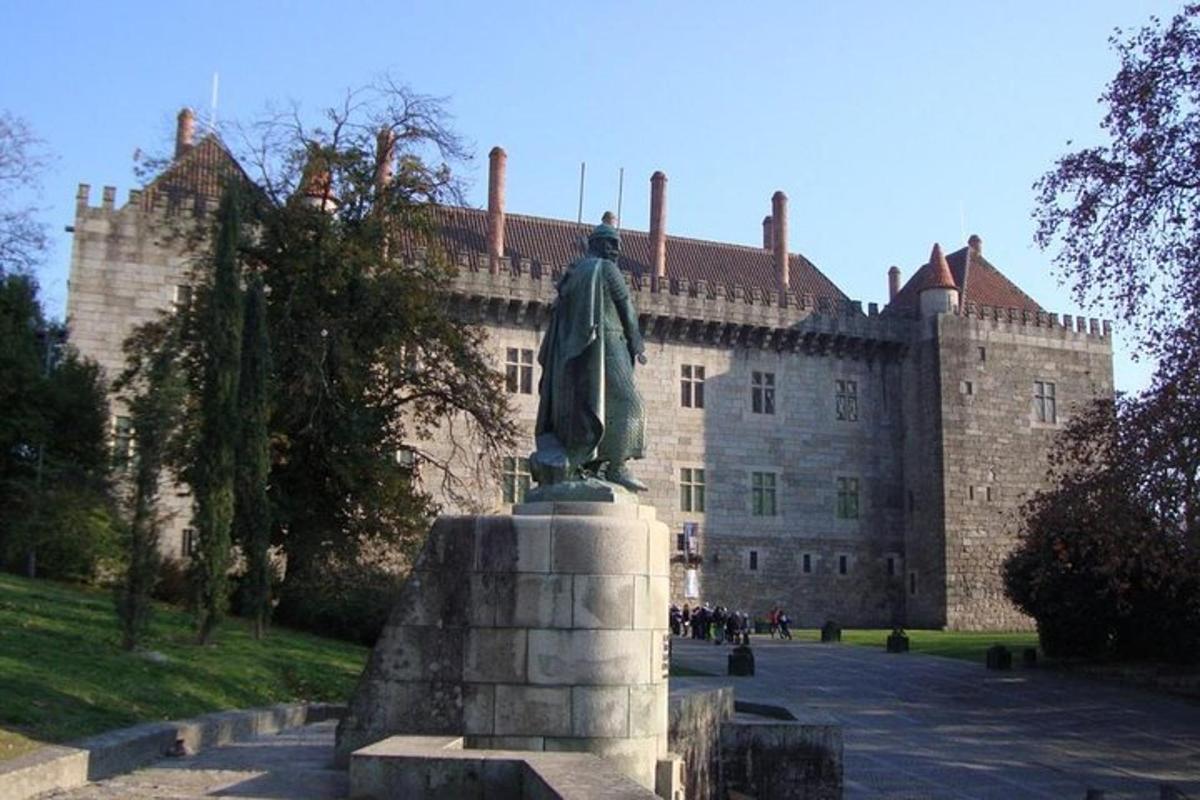 uma estátua de um homem em frente a um castelo