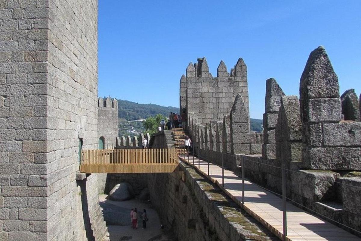 pohled na hrad s lidmi jdoucími po mostě