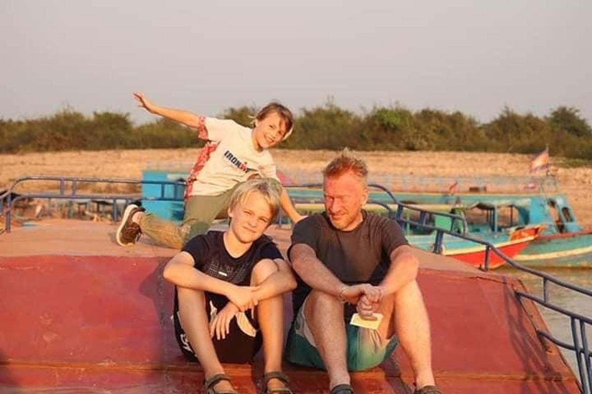 ein Mann und zwei Kinder sitzen auf einem Boot
