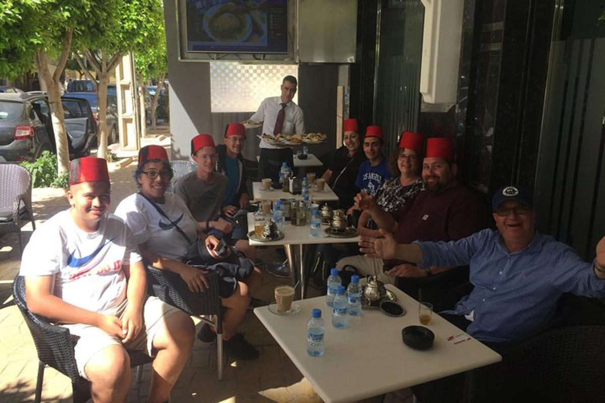 laudade taga istuv punaste mütsidega inimeste grupp