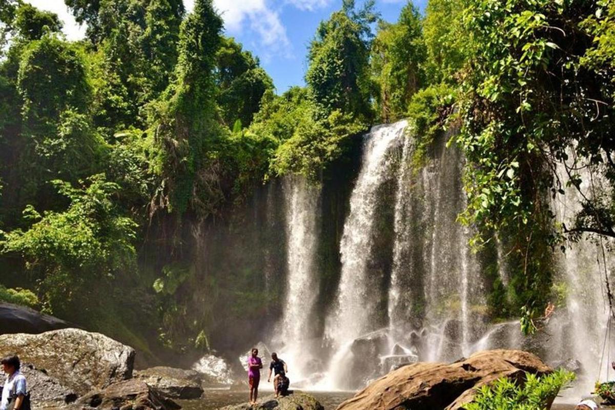 persone in piedi davanti a una cascata