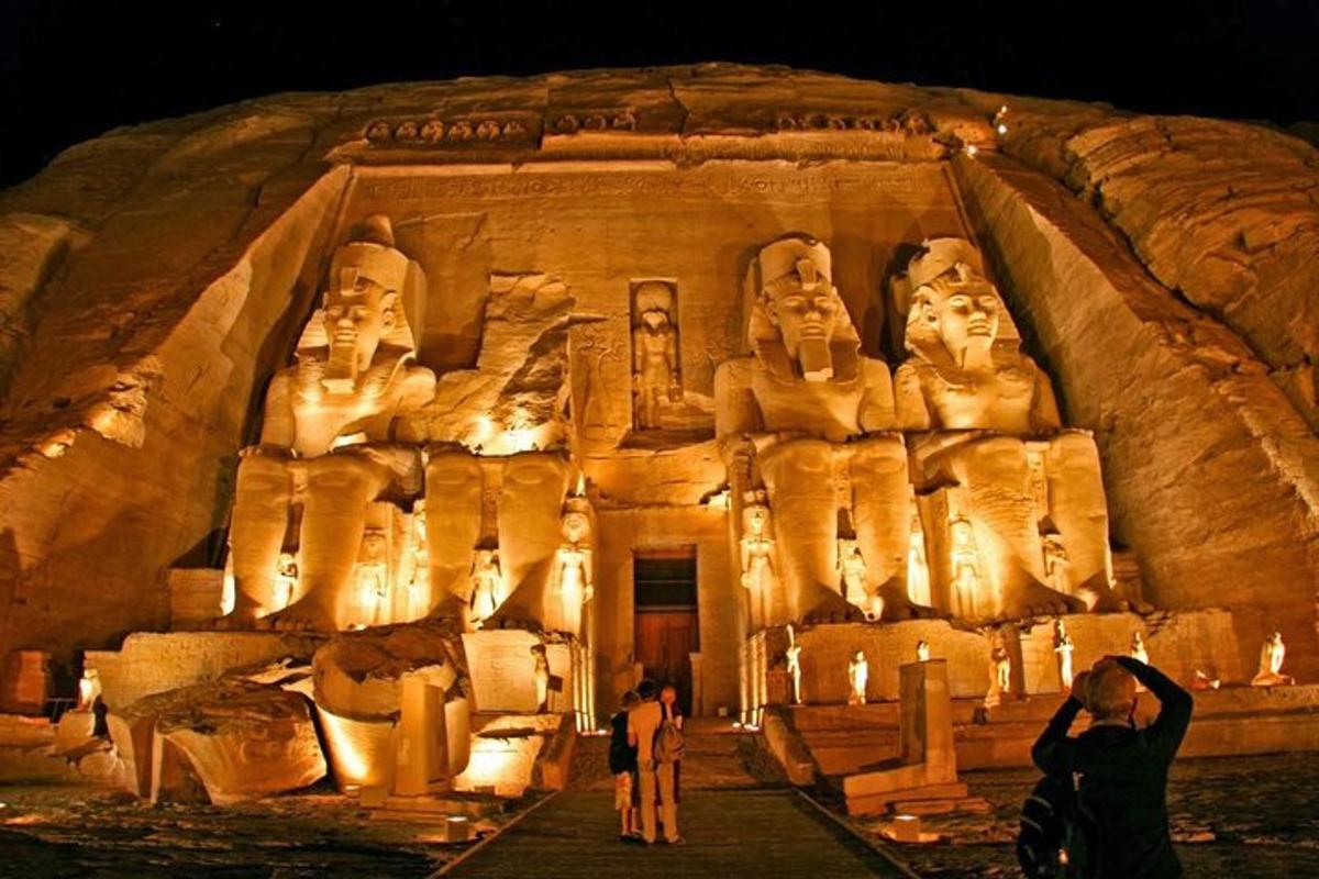 um grande templo de pedra com pessoas em pé na frente