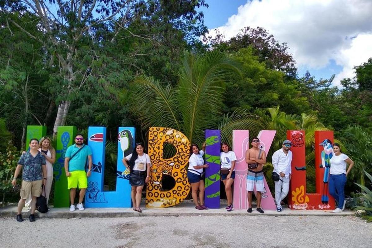 a group of people standing in front of a colorful sign