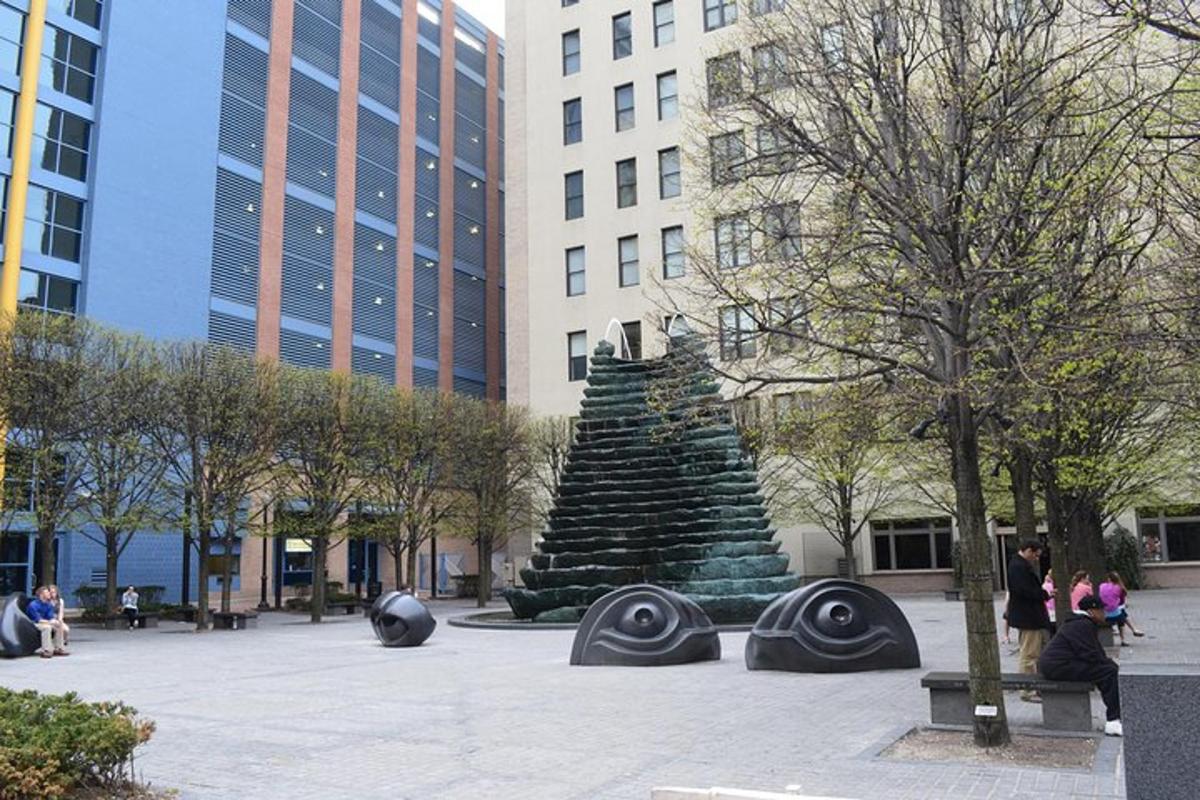 a statue in the middle of a city with buildings