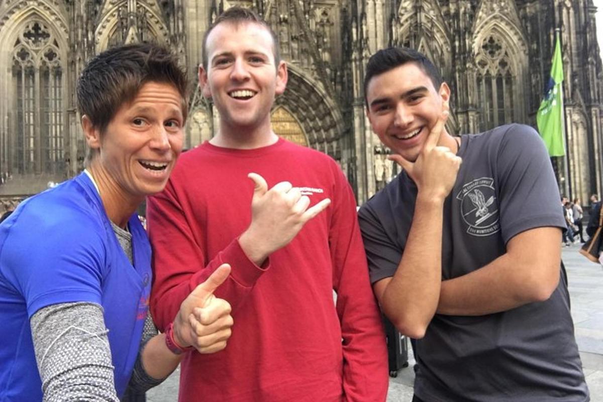 um grupo de três pessoas em pé em frente a uma catedral