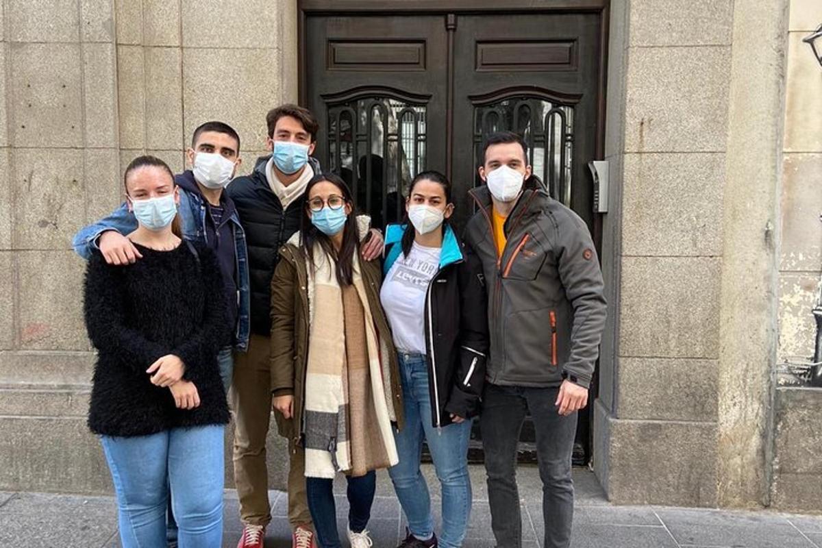 egy csoport maszkot viselő ember egy ajtó előtt