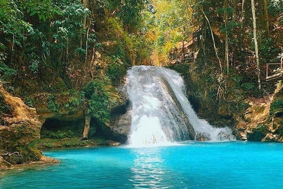 una cascada en medio de una piscina de agua azul
