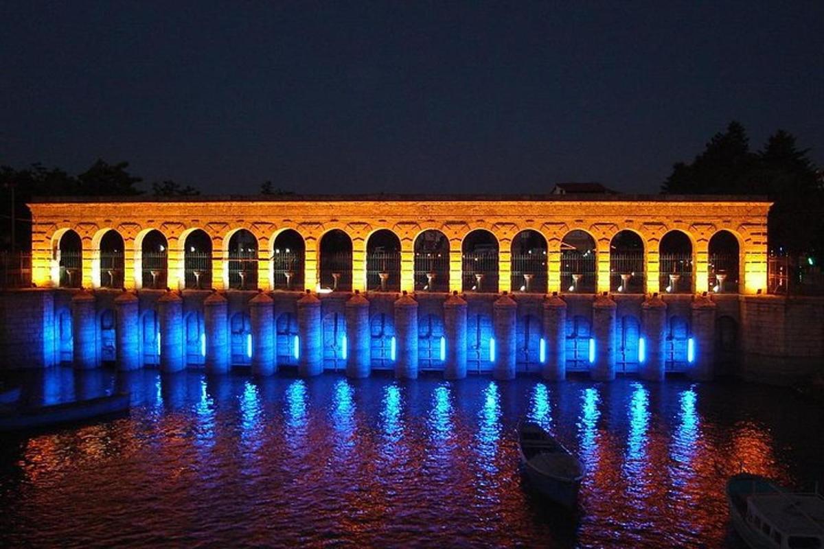 a building with blue lights on the water at night