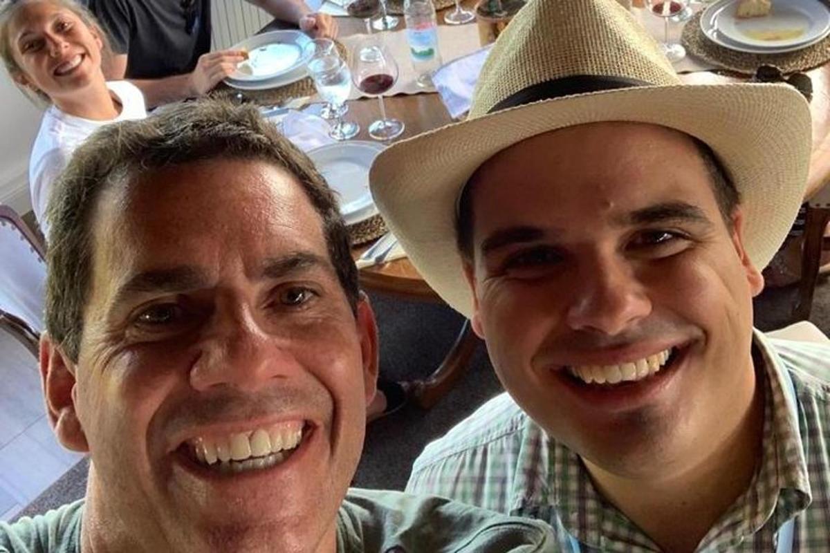 due uomini seduti a un tavolo che indossano un cappello da cowboy