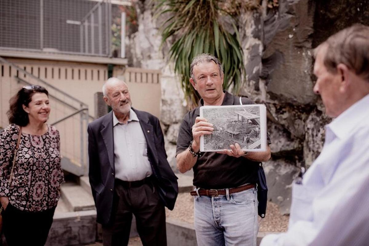 μια ομάδα ανθρώπων που στέκεται γύρω από έναν άνδρα που κρατάει έναν χάρτη
