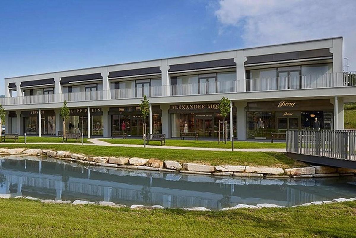 um grande edifício com um lago na frente