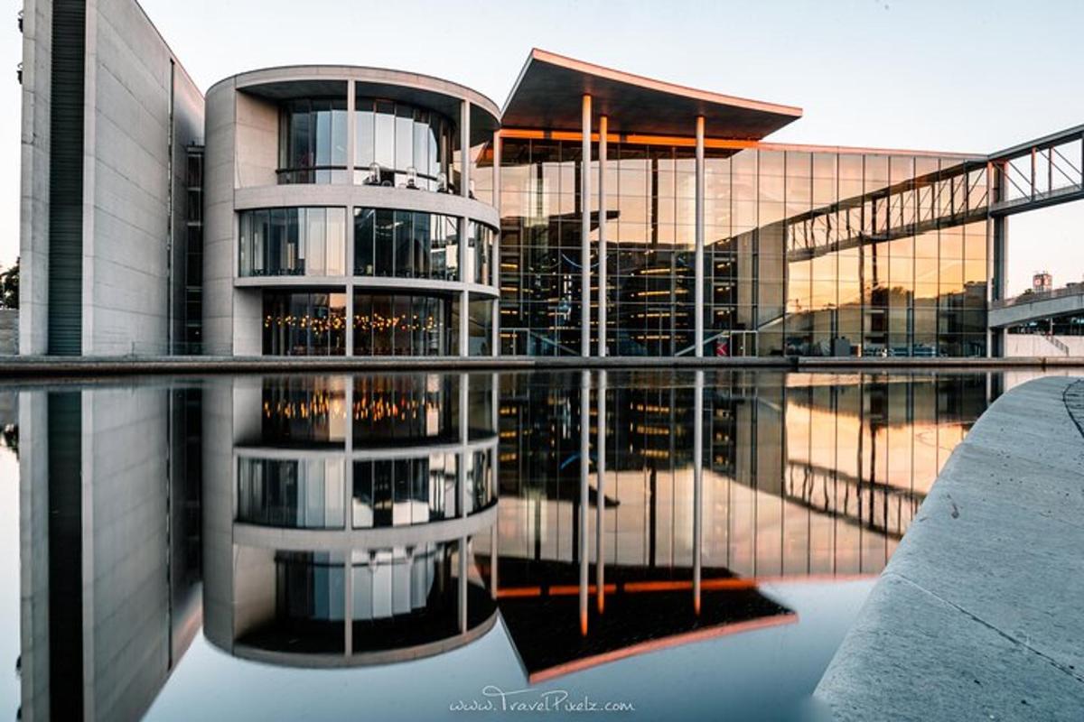 ein Gebäude mit seiner Spiegelung in einem Wasserbecken