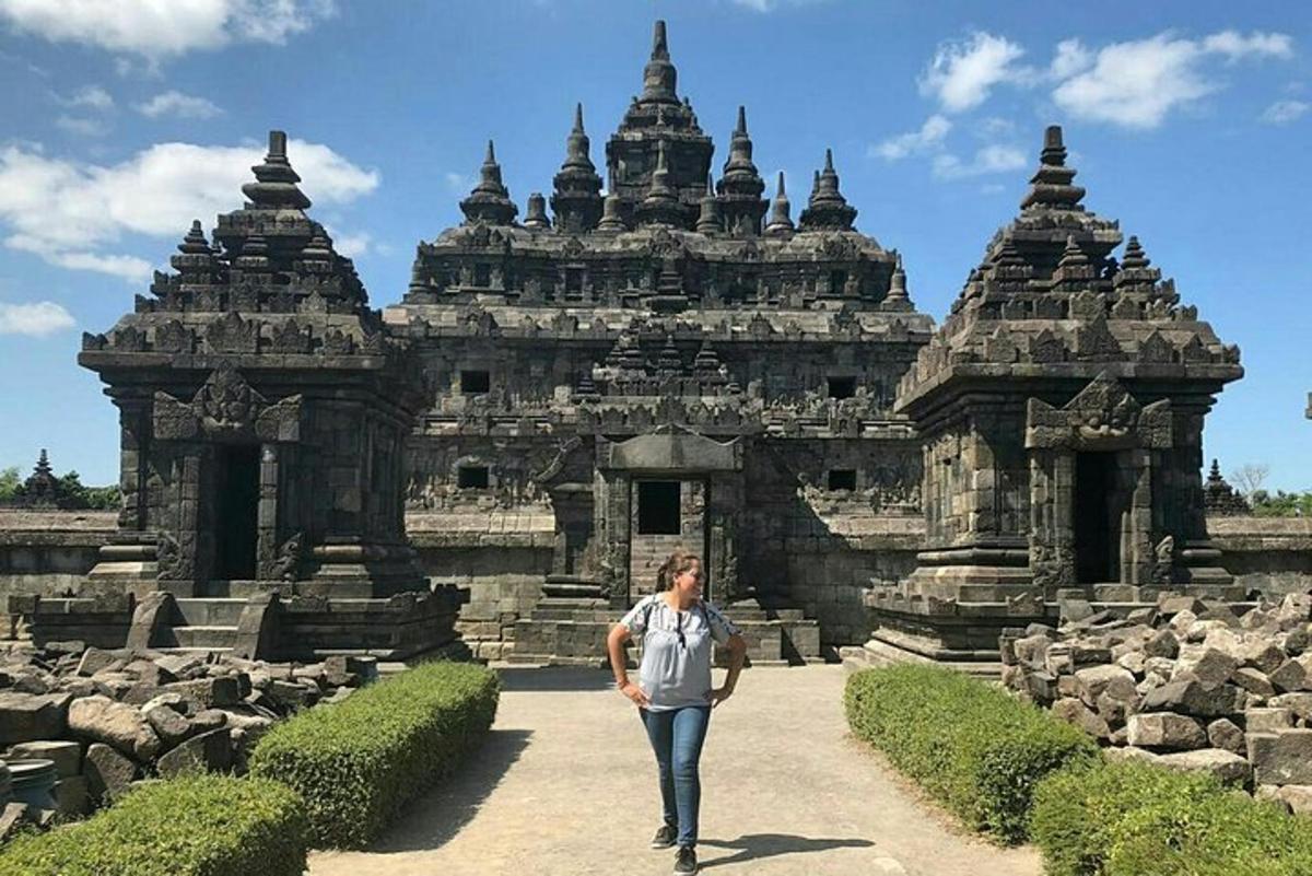 seorang lelaki berjalan di hadapan bangunan batu