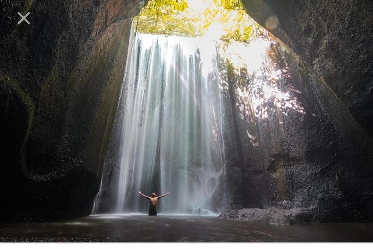 una persona in piedi davanti a una cascata