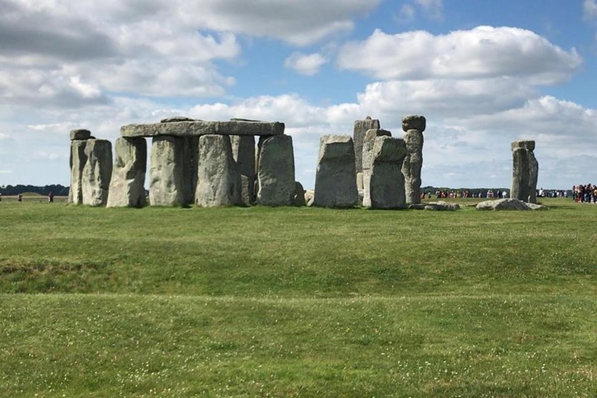an old stonehenge monument in a field of grass