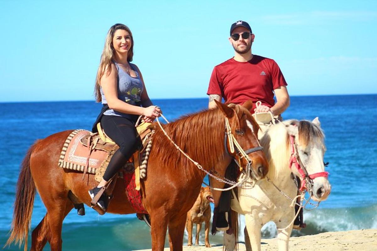 un uomo e una donna a cavallo sulla spiaggia
