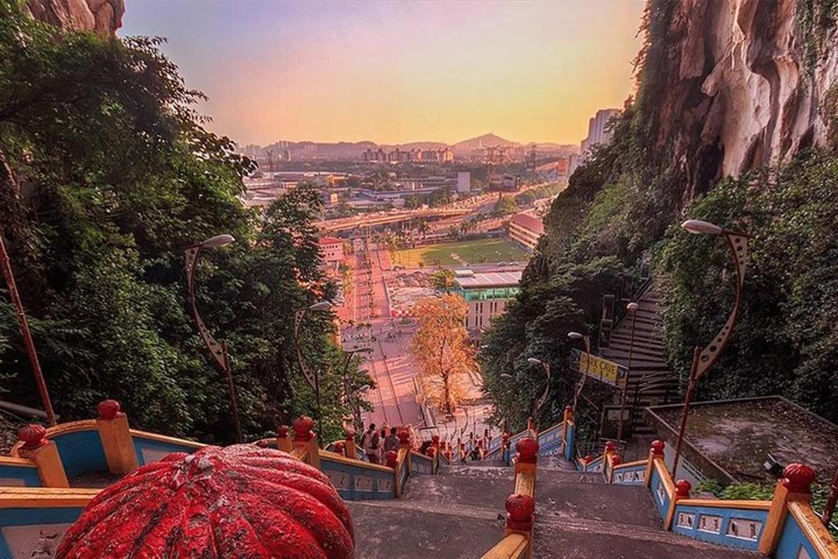 a person with a red umbrella looking down a mountain
