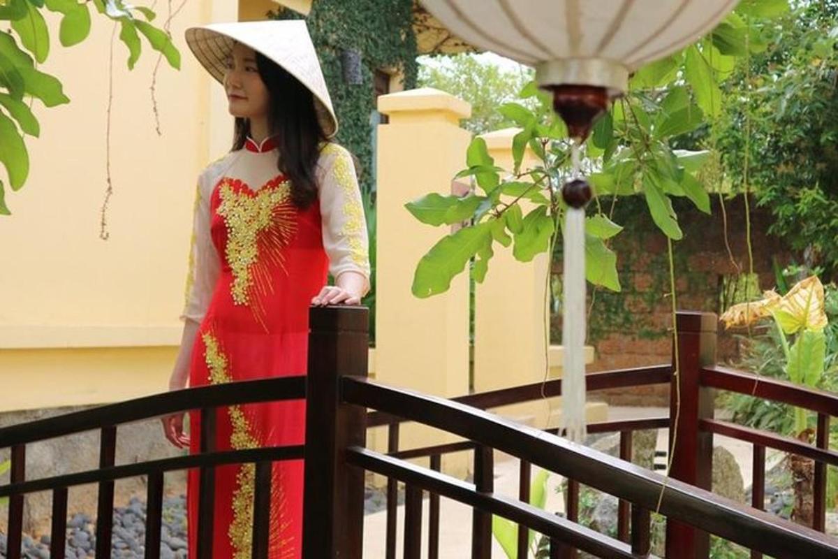 a woman in a red dress and hat standing on a fence