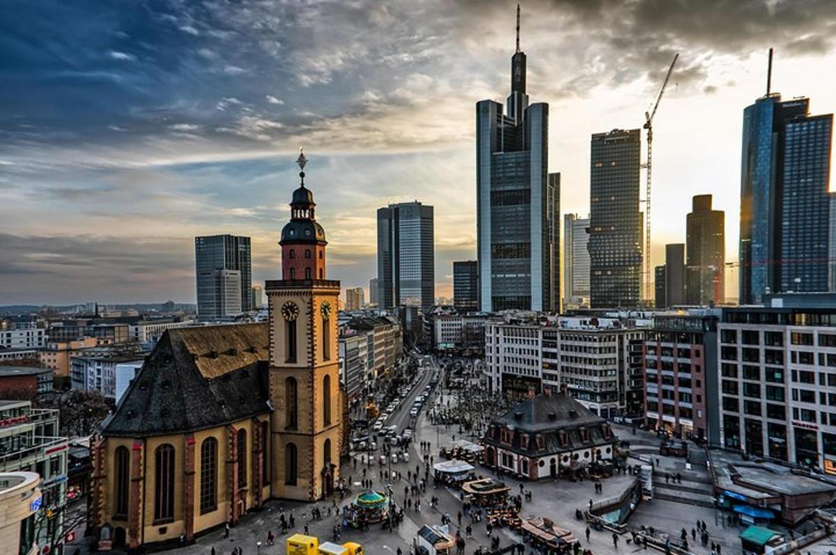 un edificio con una torre dell'orologio di fronte a una città