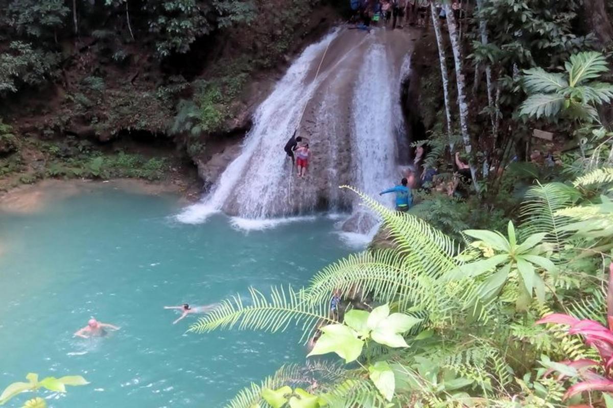 sekumpulan orang berenang di air terjun