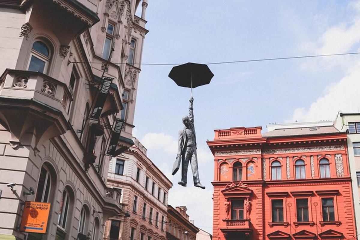 uma estátua de um homem com um guarda-chuva pendurada entre dois prédios