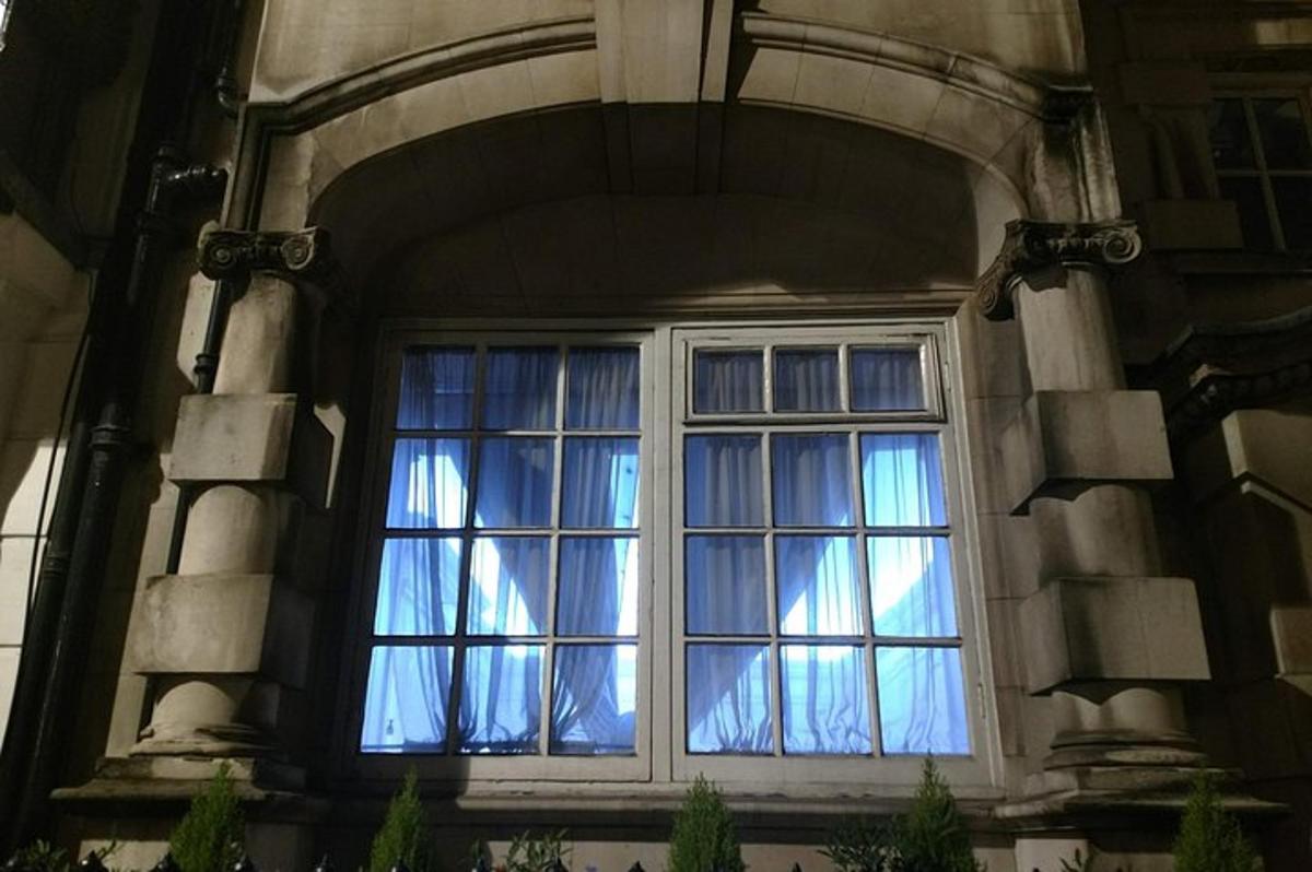 Una ventana en un edificio de piedra con cortinas azules.