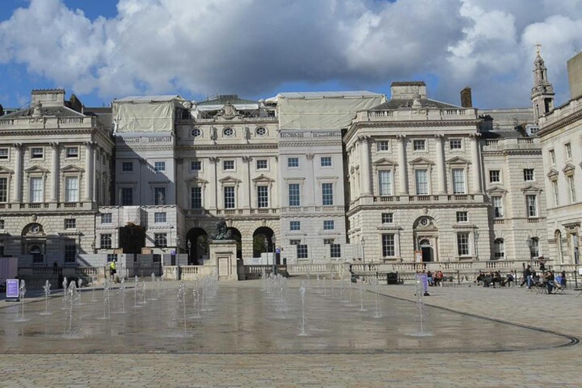 un grande edificio con una fontana di fronte