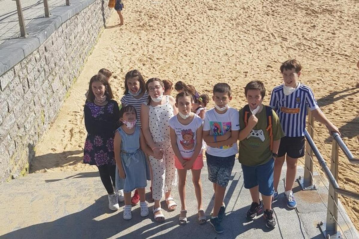 en gruppe barn som poserer for et bilde på stranden