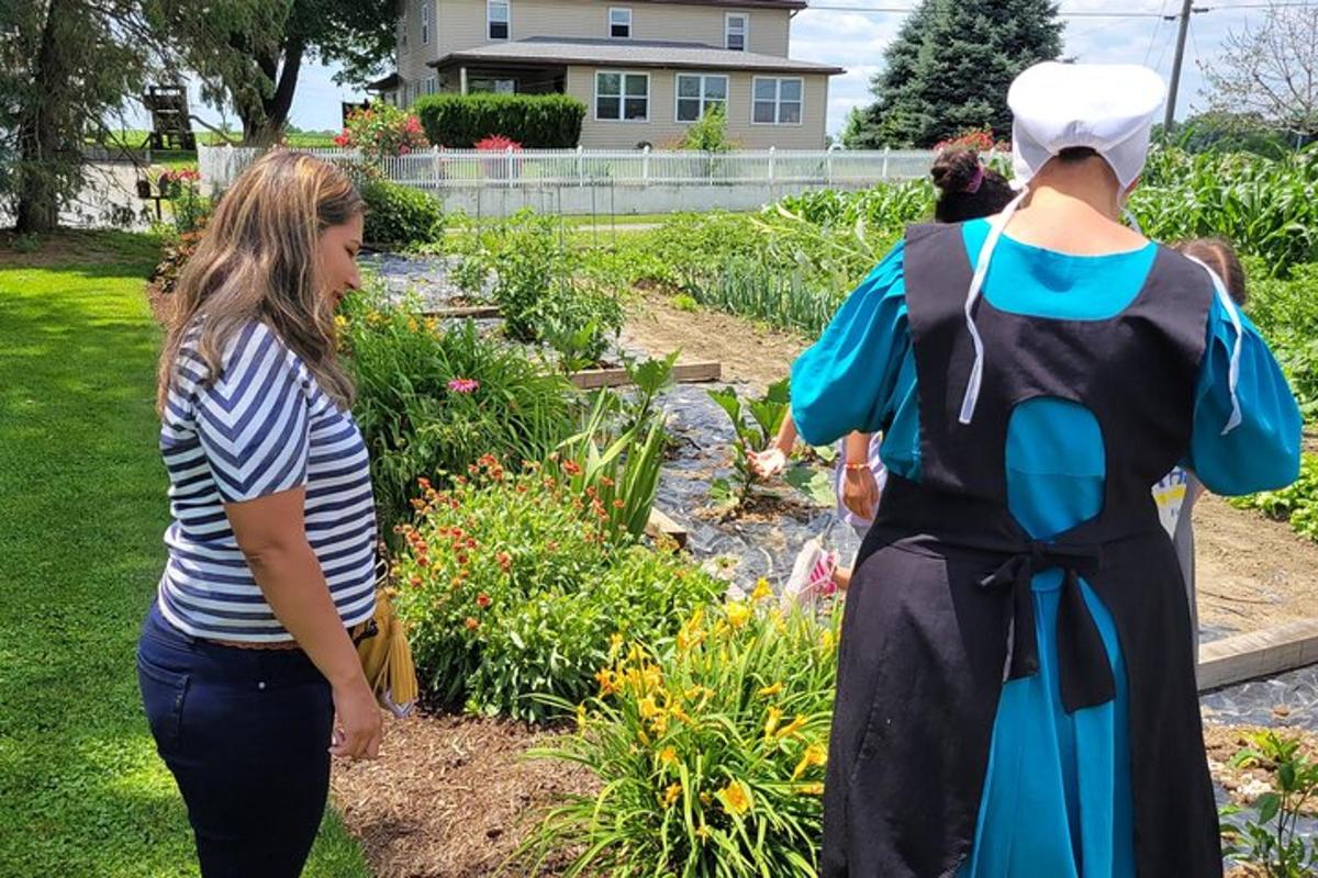 a woman standing next to a mannequin in a garden