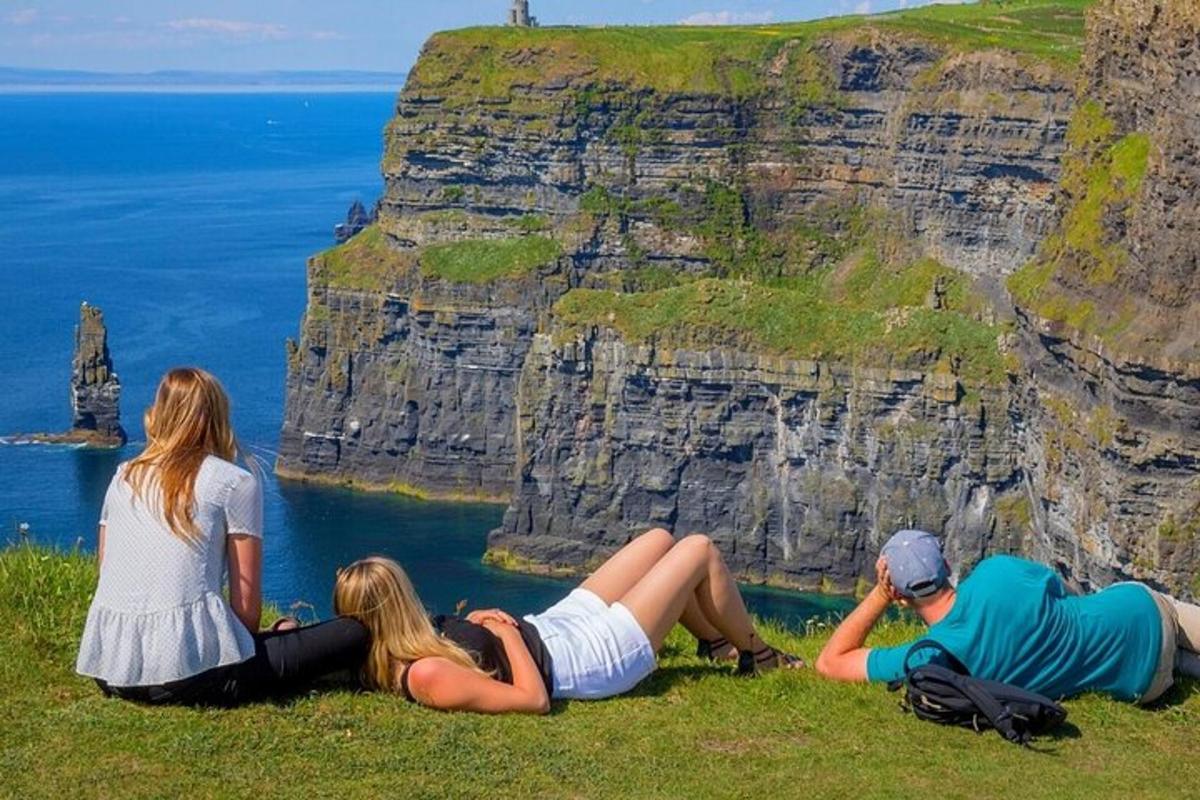 a group of people sitting on top of a cliff