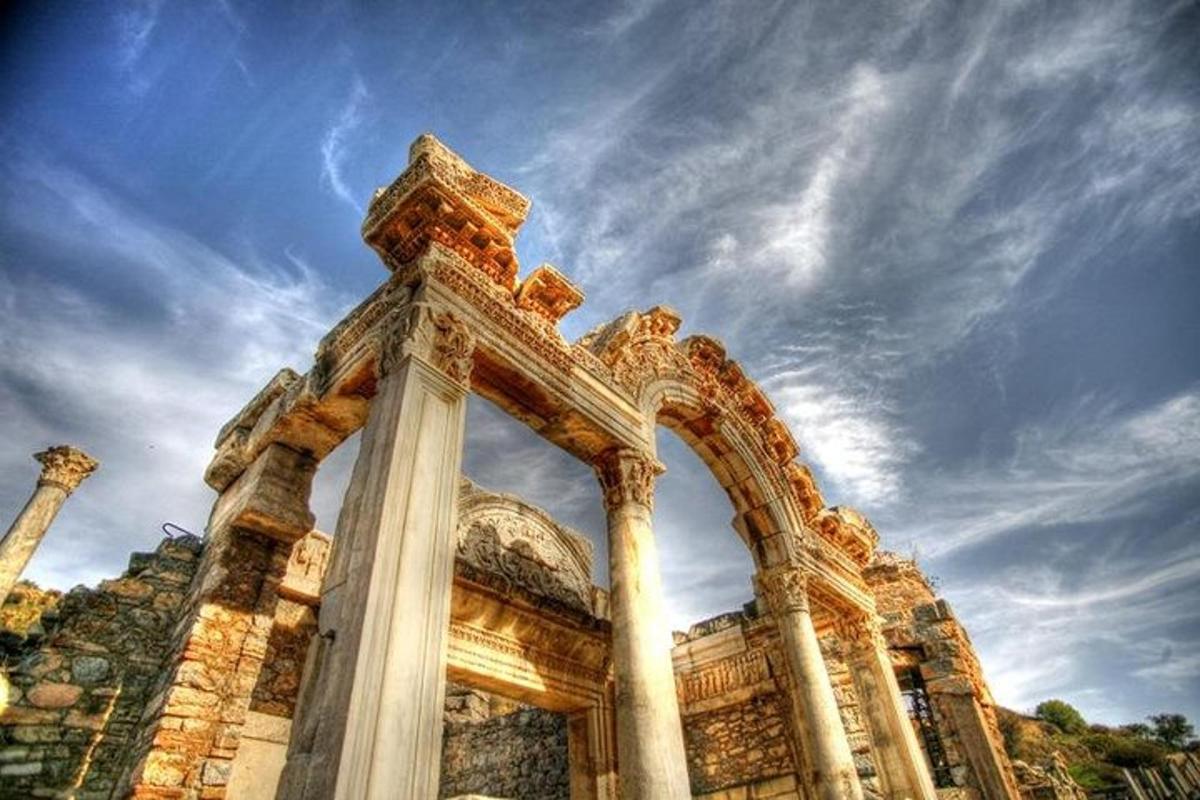a building with columns and a cloudy sky