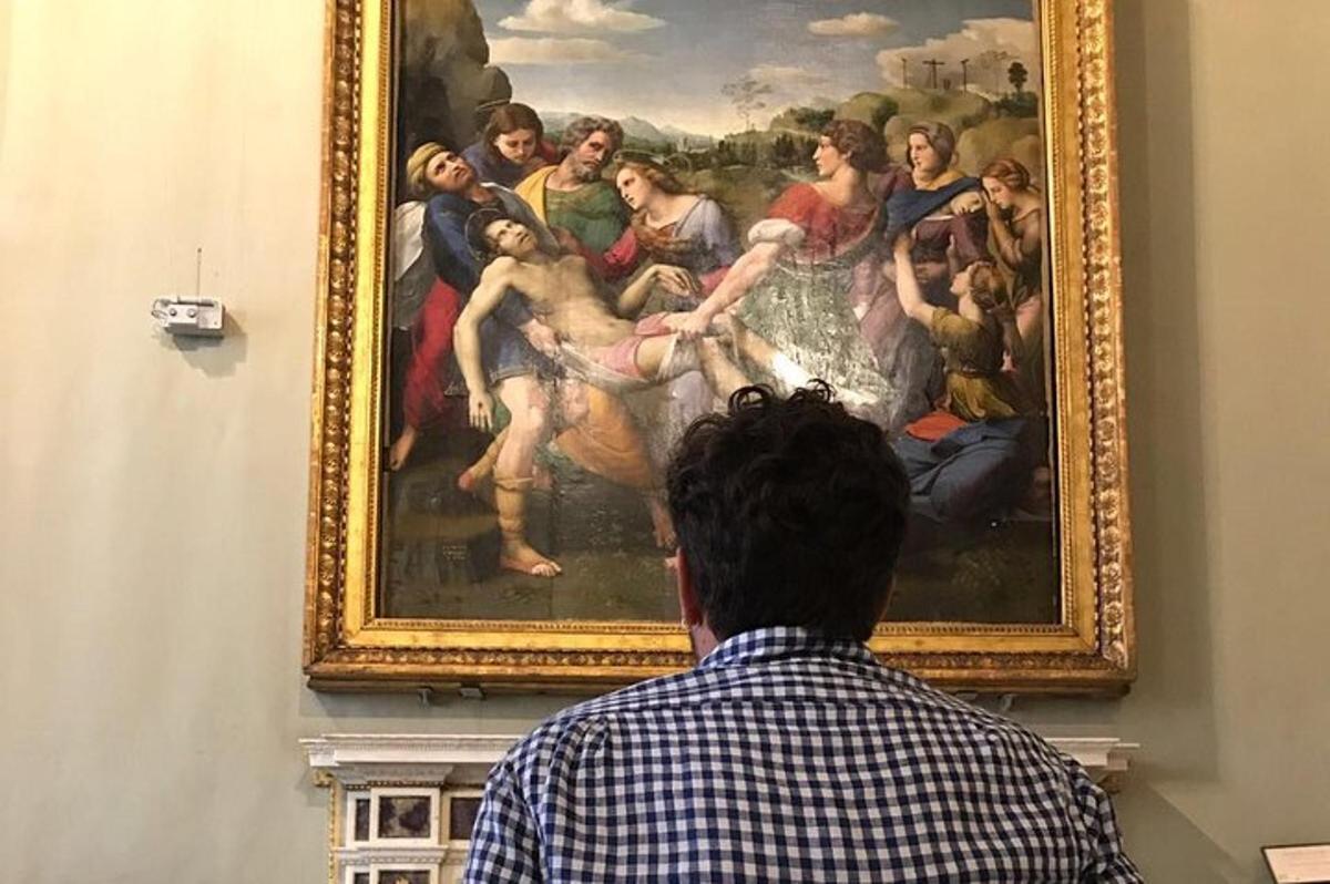 un hombre mirando un cuadro en un museo
