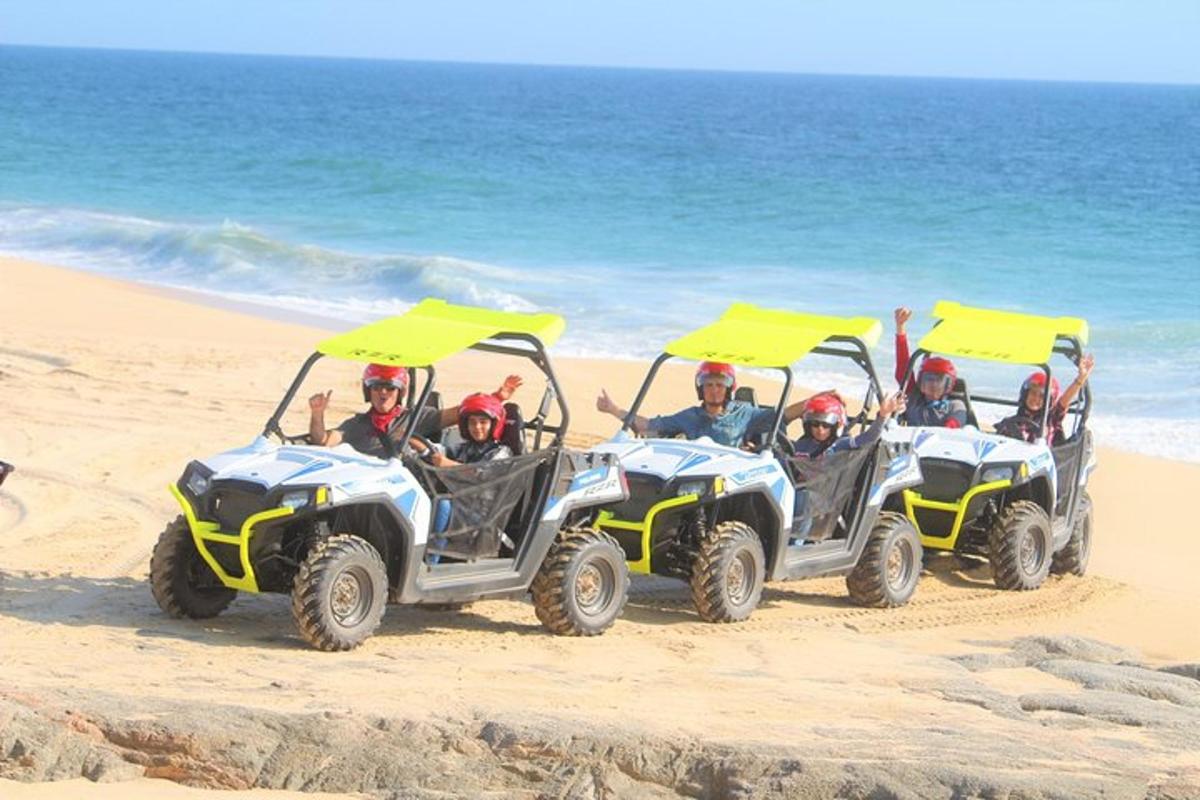 een groep mensen die op quads op het strand rijden