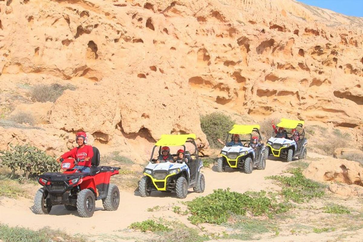 een groep mensen die op een onverharde weg met quads rijden