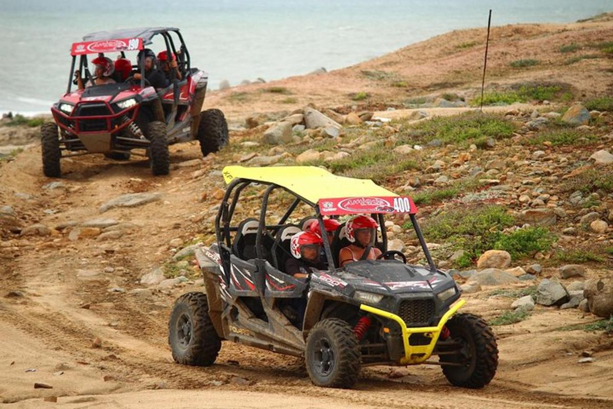 două persoane care călătoresc cu ATV-uri pe un drum de pământ