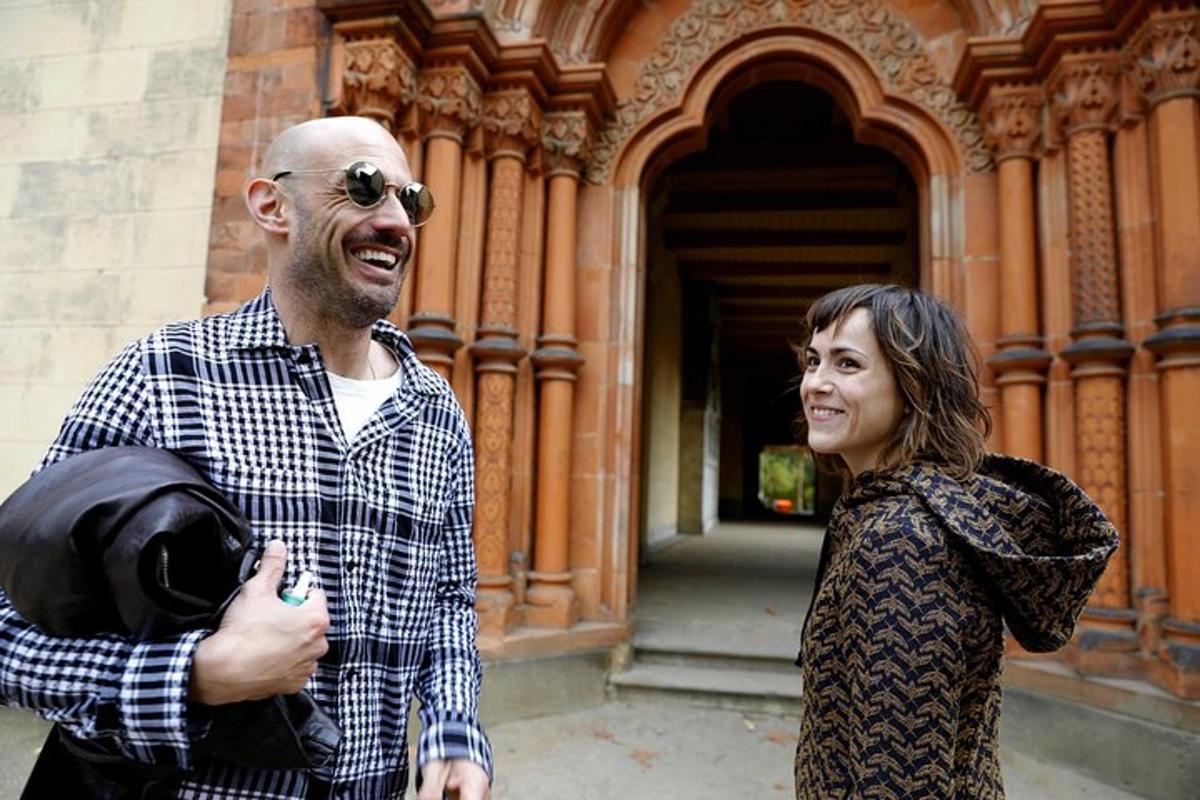 a man and a woman standing in front of a building