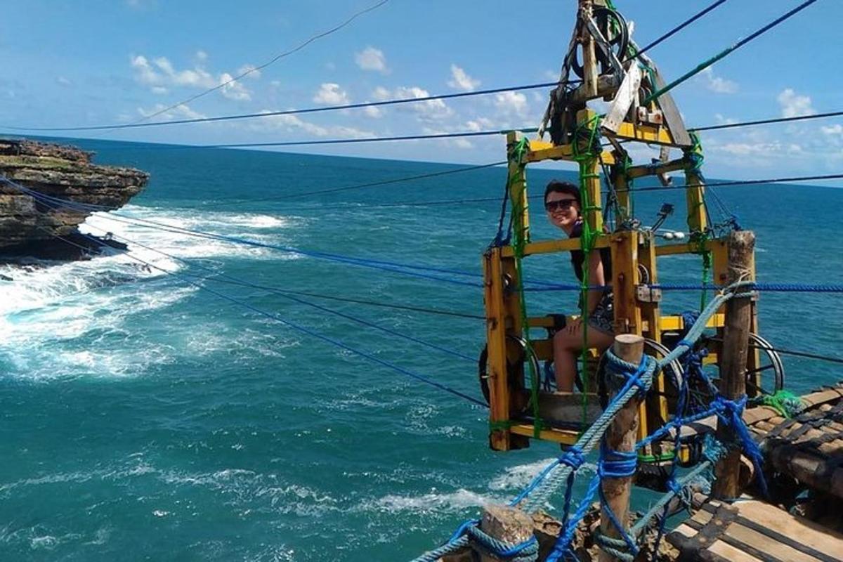 một người đàn ông ngồi trên một sợi dây đu trên biển