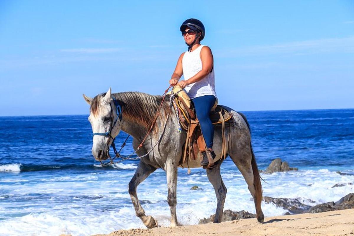 eine Frau, die am Strand reitet