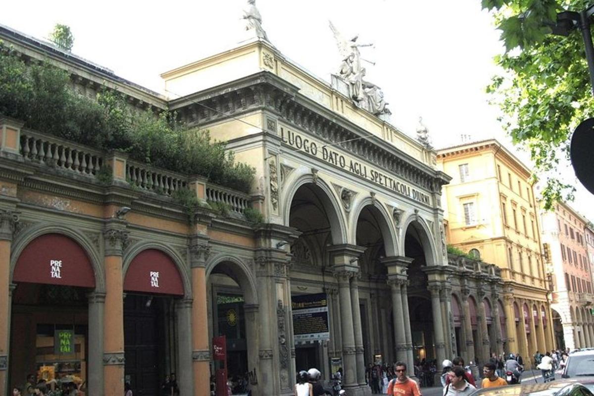 Un gran edificio con gente caminando frente a él.