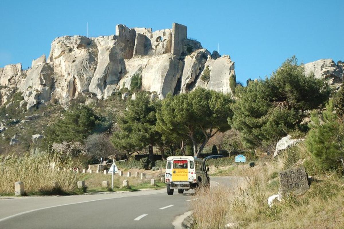 a truck driving down a road in front of a mountain