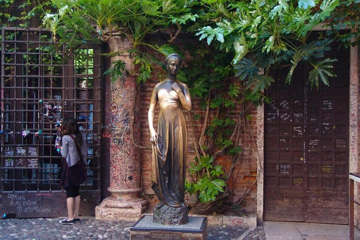 una donna in piedi accanto a una statua di una donna