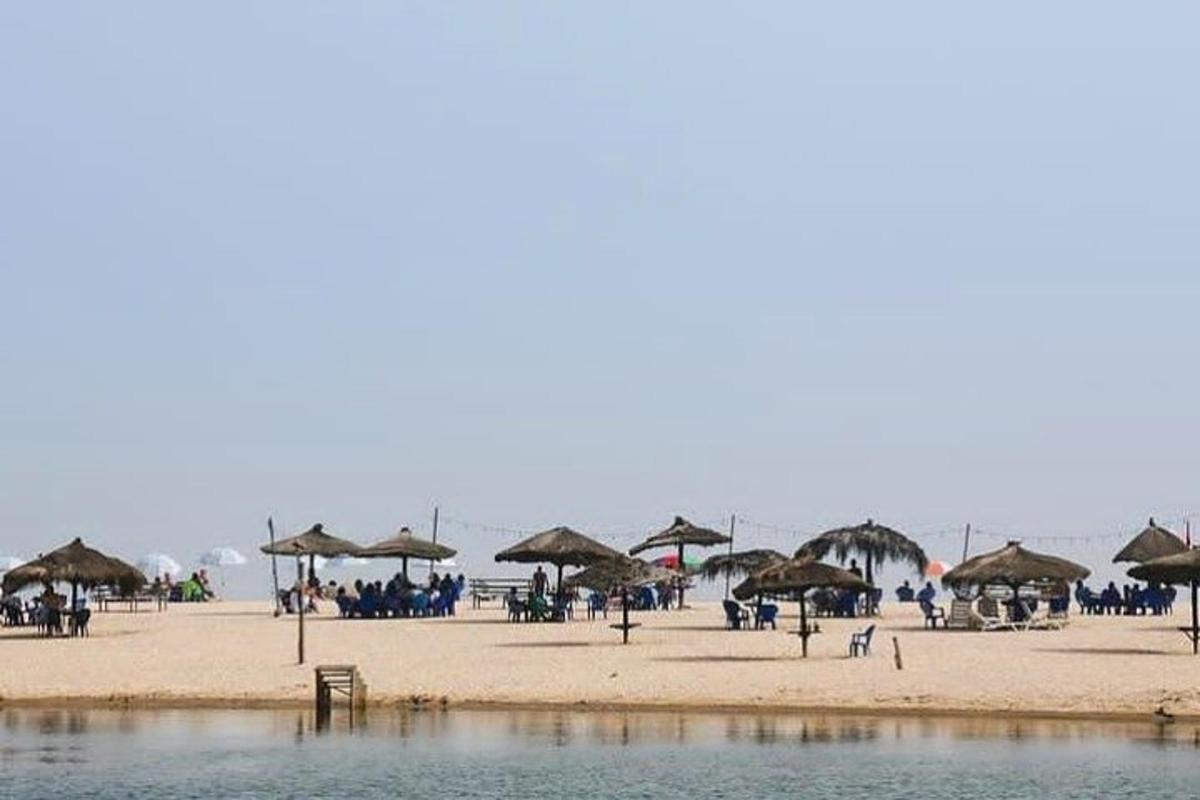 una spiaggia con ombrelloni e persone sedute sulla spiaggia