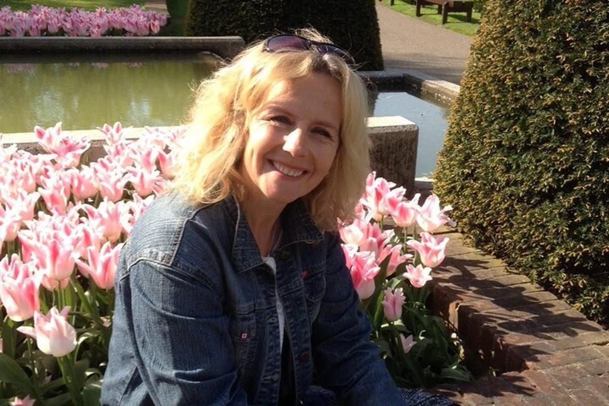 žena sedící před růžovými tulipány