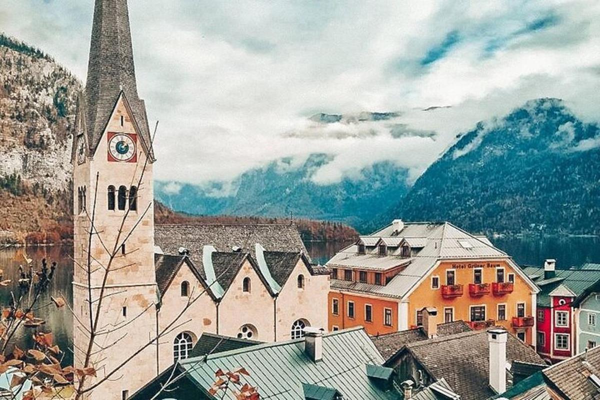 a church with a clock tower in a town with mountains