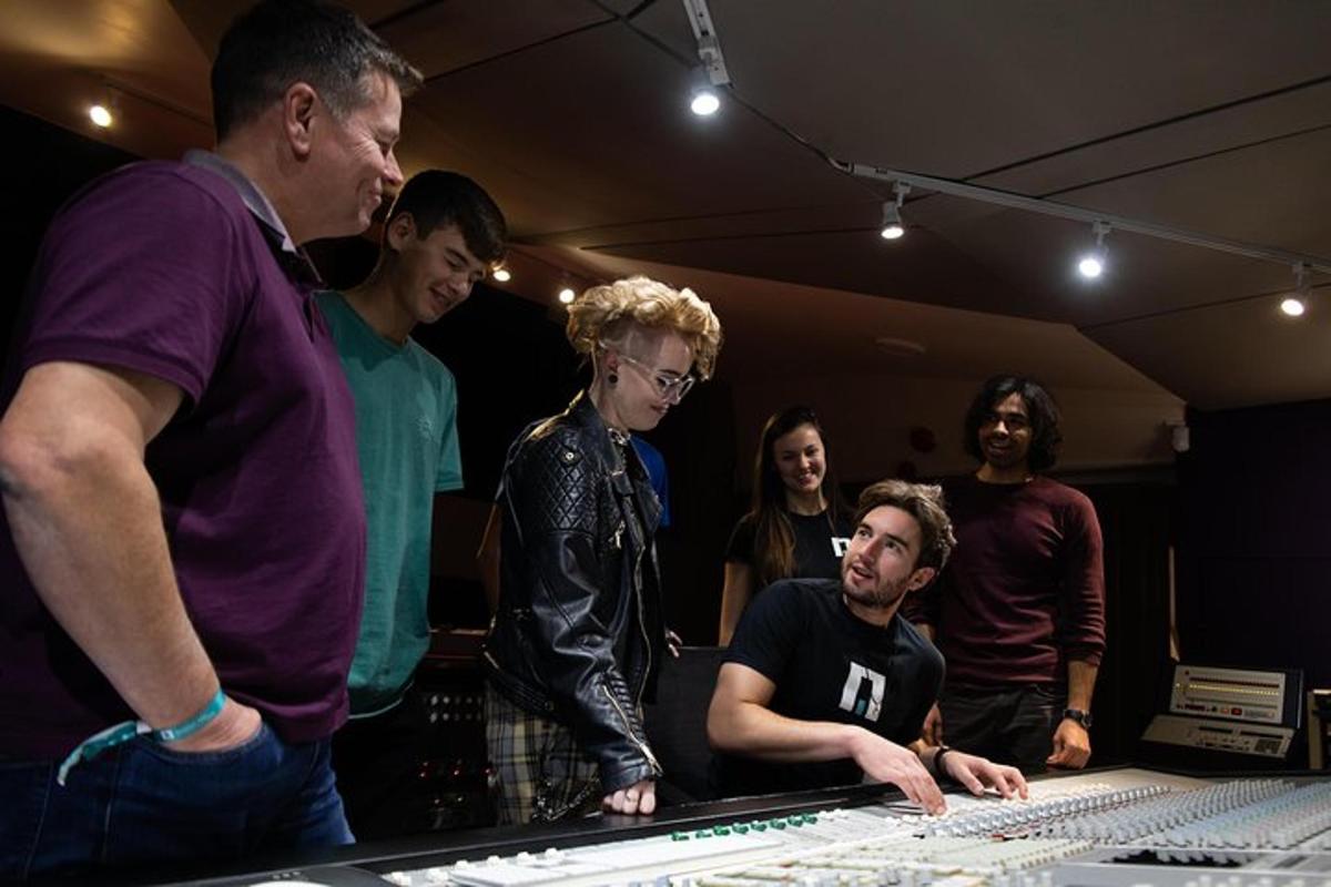 a group of people standing around a mixing console