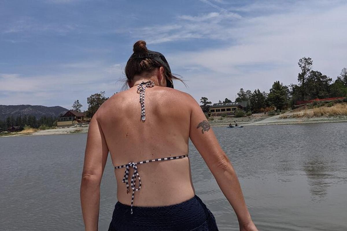 kobieta w bikini stojąca obok zbiornika wodnego