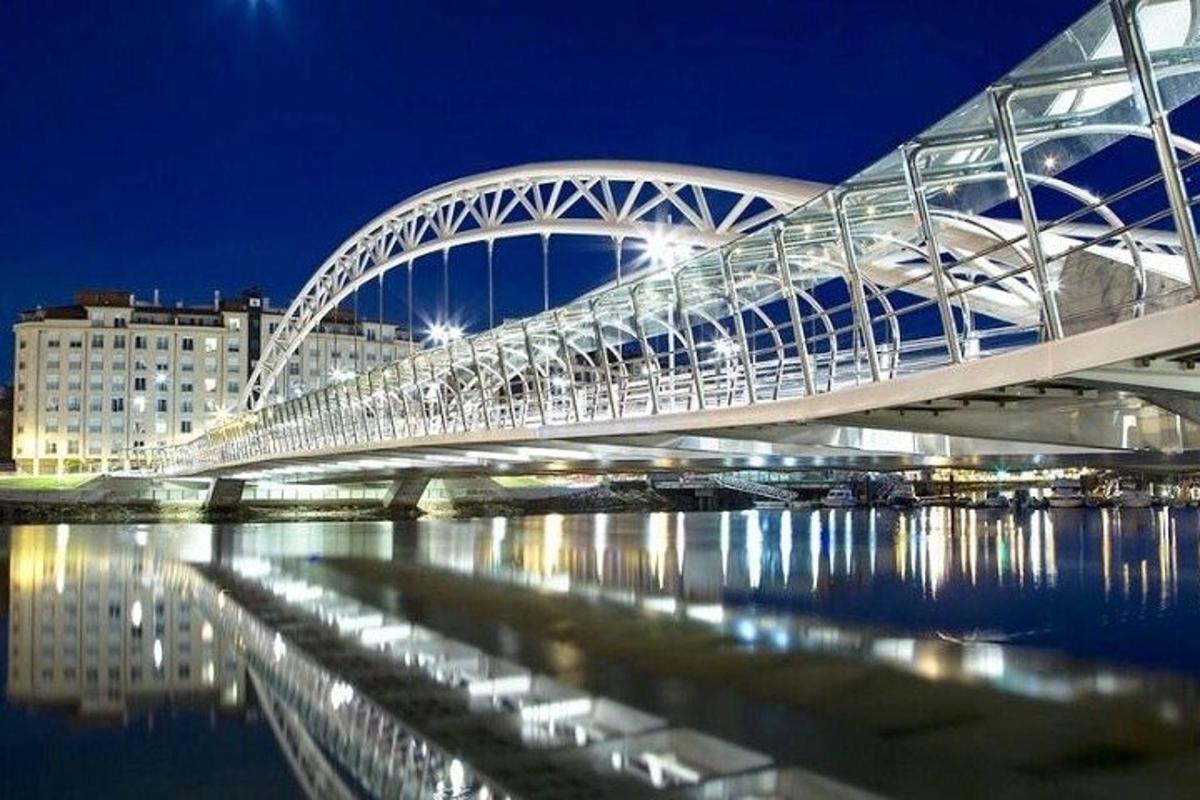 a large white bridge over water at night