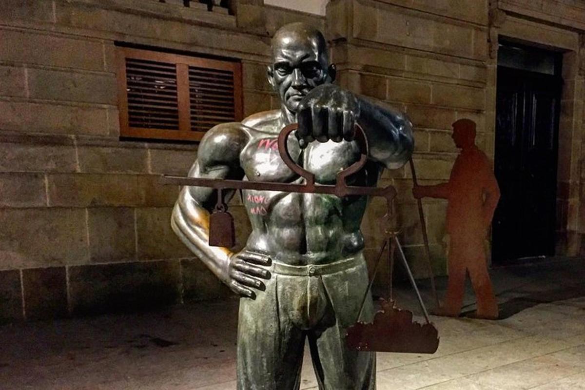 a bronze statue of a man holding a spear
